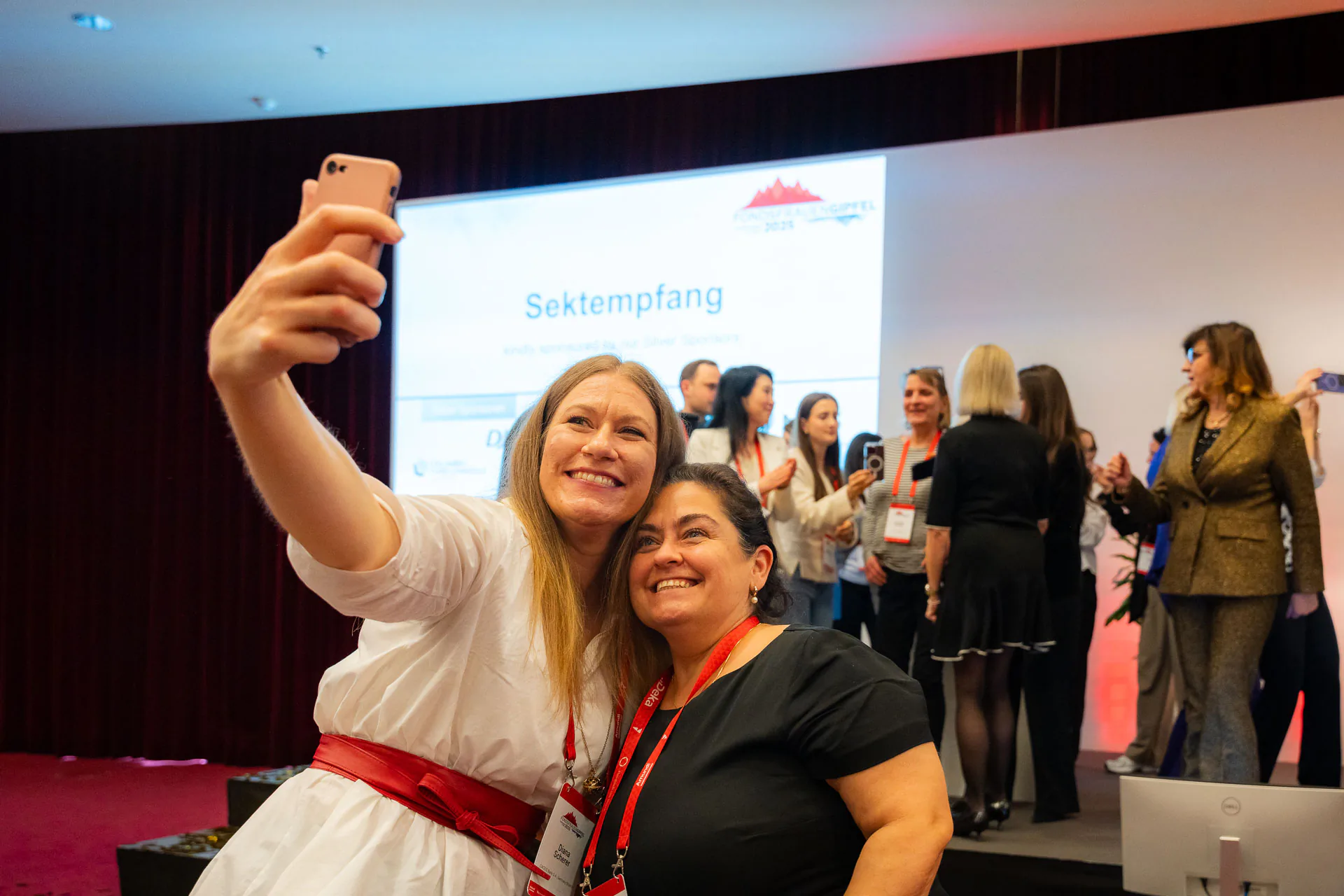 Zwei Teilnehmerinnen bei einem Selfie vor der Bühne